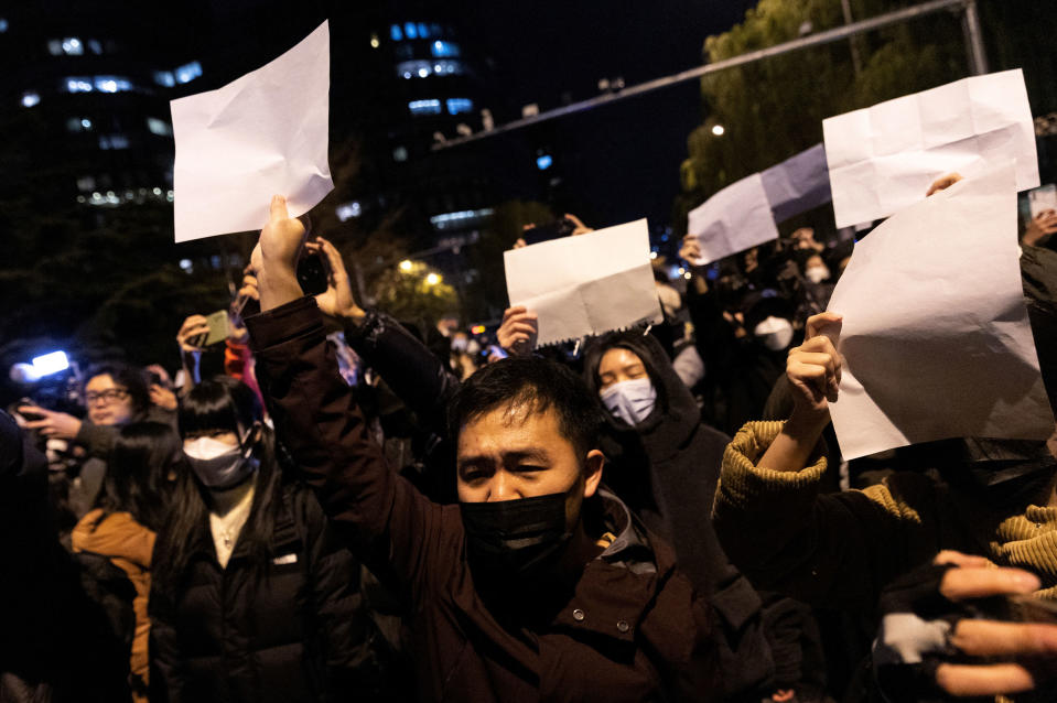 People hold white sheets of paper in protest over COVID-19 restrictions, after a vigil for the victims of a fire in Urumqi, as outbreaks of COVID-19 continue, in Beijing, China, on Nov. 28, 2022.<span class="copyright">Thomas Peter—Reuters</span>