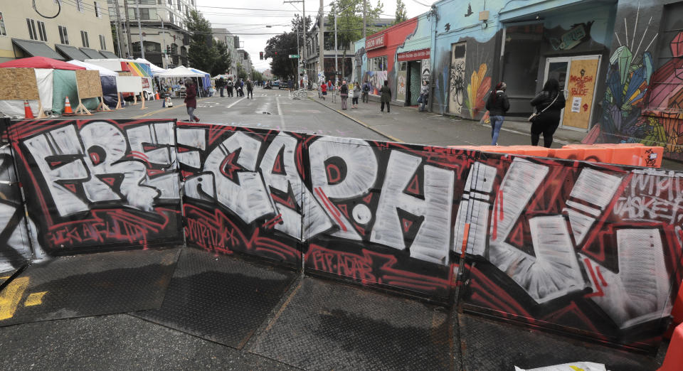 A sign at an entrance to what has been named the Capitol Hill Occupied Protest zone in Seattle reads "Free Cap Hill," Monday, June 15, 2020. Protesters have taken over several blocks near downtown Seattle after officers withdrew from a police station in the area following violent confrontations. (AP Photo/Ted S. Warren)