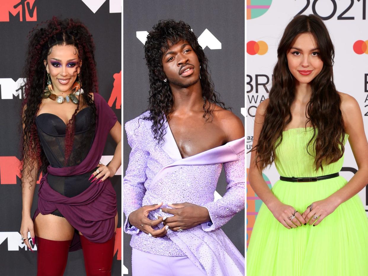 left: a photo of doja cat in a black strapless top and maroon fabric over it on the red carpet at the VMAs; center: lil nas x in an off-the-shoulder purple outfit at the VMAs with long hair; right: olivia rodrigo at the BRITs in a neon green dress