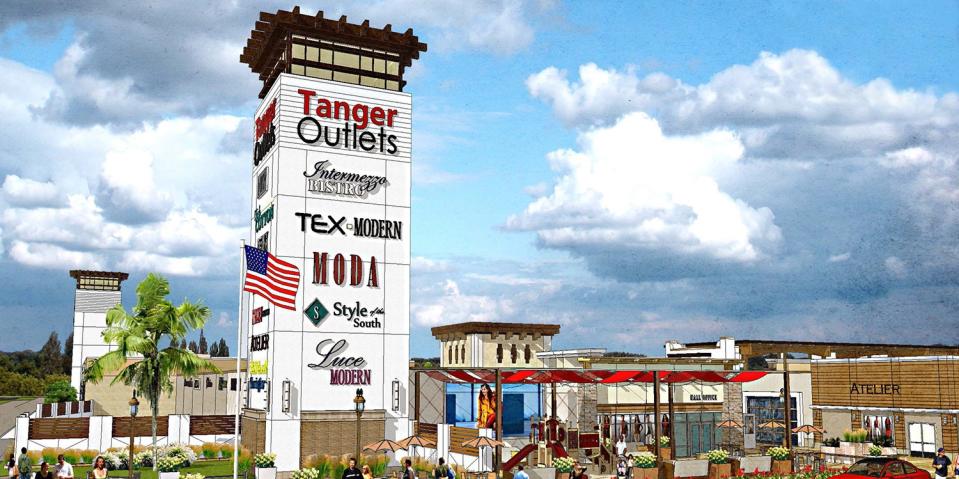 Tanger Outlets tower in front of an outlet shopping center.