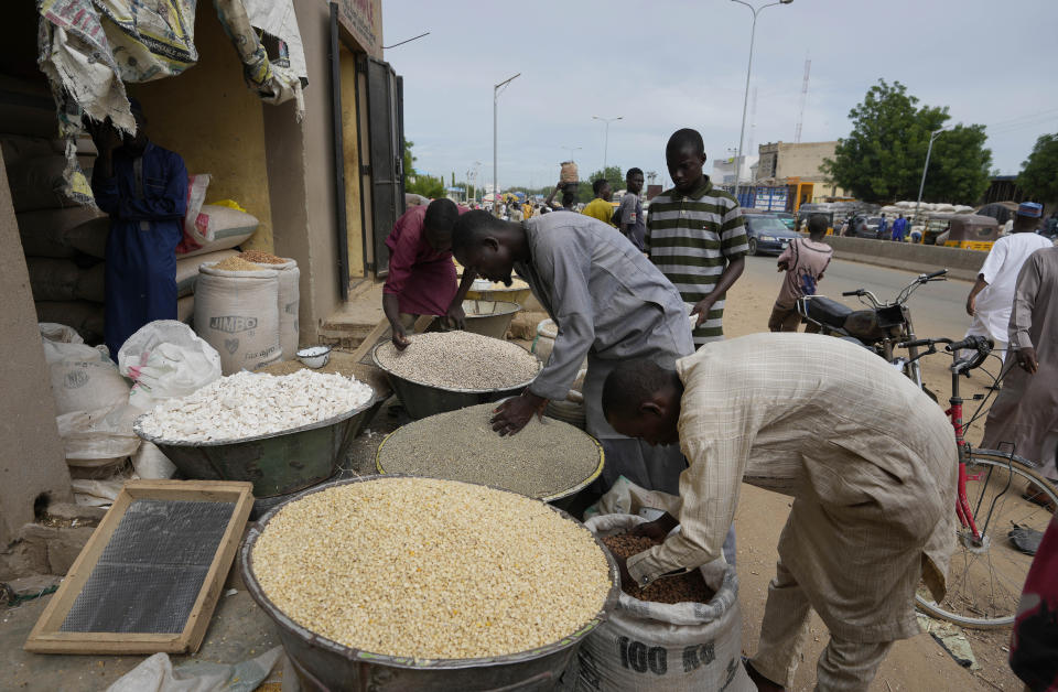 People sell grain in Dawanau International Market in Kano Nigeria, Friday, July 14, 2023. Nigeria introduced programs before and during Russia's war in Ukraine to make Africa's largest economy self-reliant in wheat production. But climate fallout and insecurity in the northern part of the country where grains are largely grown has hindered the effort. (AP Photo/Sunday Alamba)