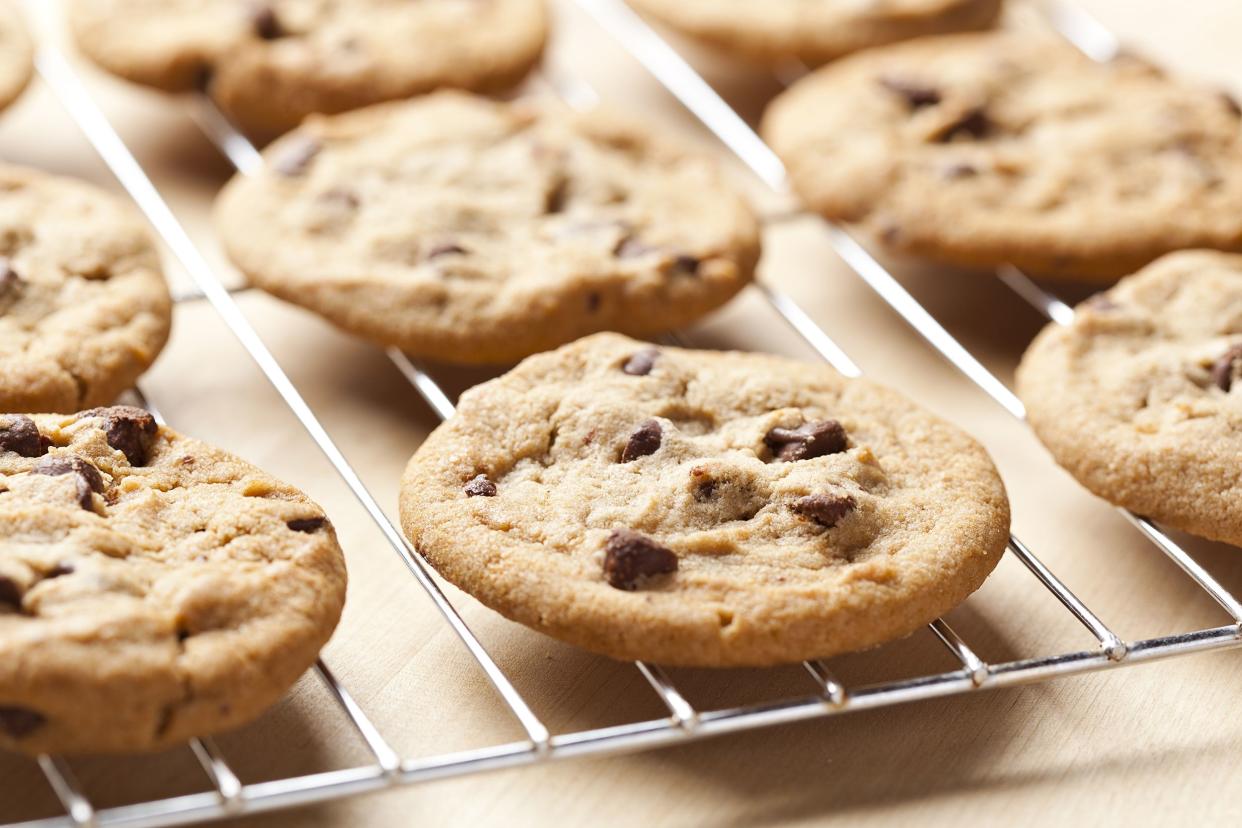 Closeup of several five-ingredient chocolate chip cookies lined up on a metal rack with a table underneath