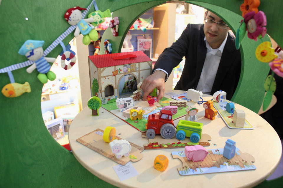 LONDON, ENGLAND - JANUARY 24: A man adjusts toy farmyard models on the Haba stand at the 2012 London Toy Fair, at Olympia Exhibition Centre on January 24, 2012 in London, England. The annual fair, which is organised by the British Toy and Hobby Association, brings together toy manufacturers with retailers from around the world. (Photo by Oli Scarff/Getty Images)