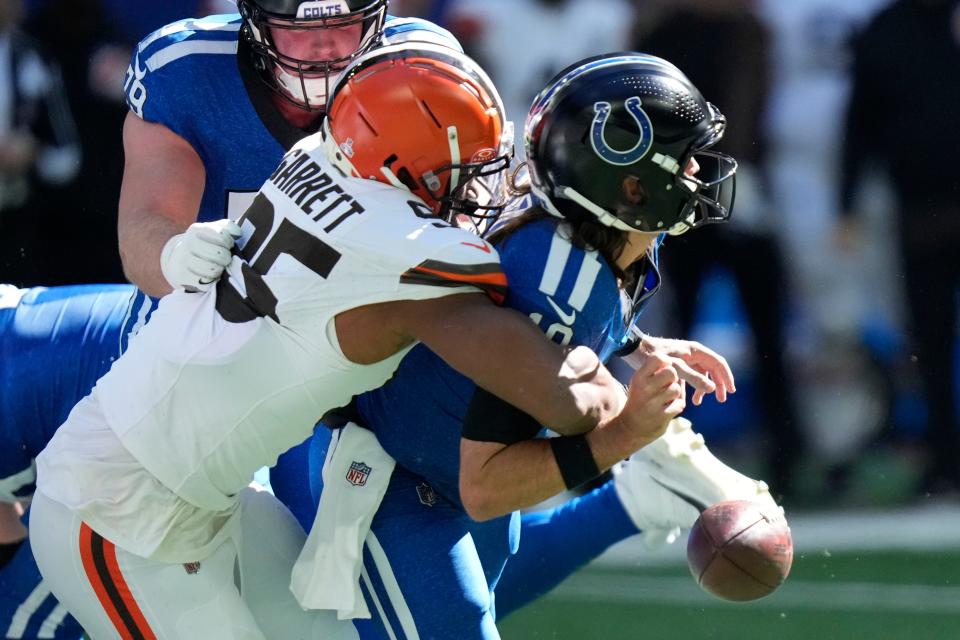 Indianapolis Colts quarterback Gardner Minshew (10) fumbles as he is sacked by Cleveland Browns defensive end Myles Garrett (95) during the first half of an NFL football game, Sunday, Oct. 22, 2023, in Indianapolis. (AP Photo/AJ Mast)