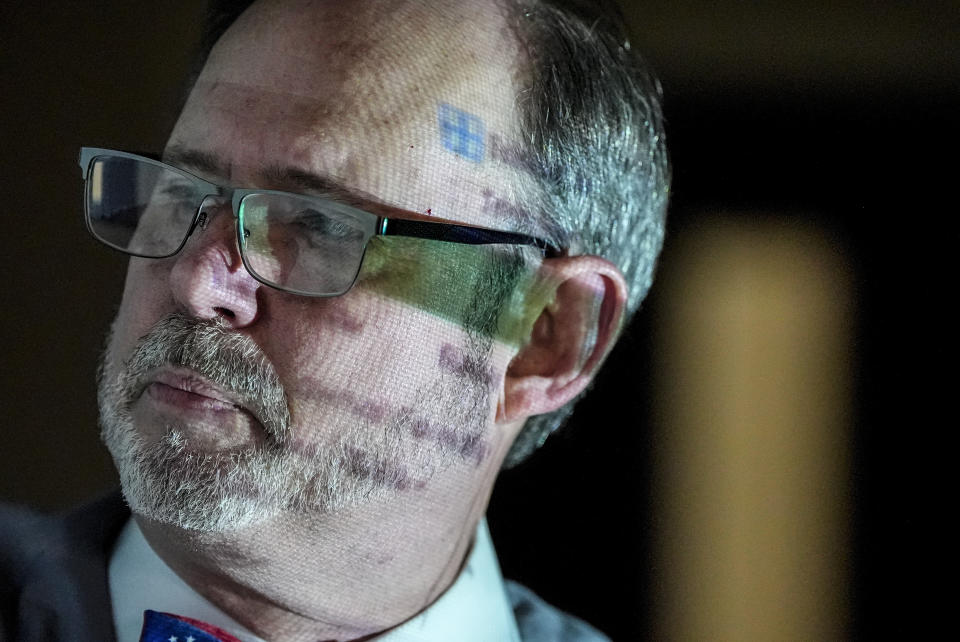 Douglas G. Frank speaks to a group of people about the Georgia election process as data is projected onto his body, Sunday, March 24, 2024, in Rome, Ga. Frank is among those urging people to file voter challenges using a software tool called EagleAI to get potentially ineligible voters removed from the registration rolls. (AP Photo/Mike Stewart)