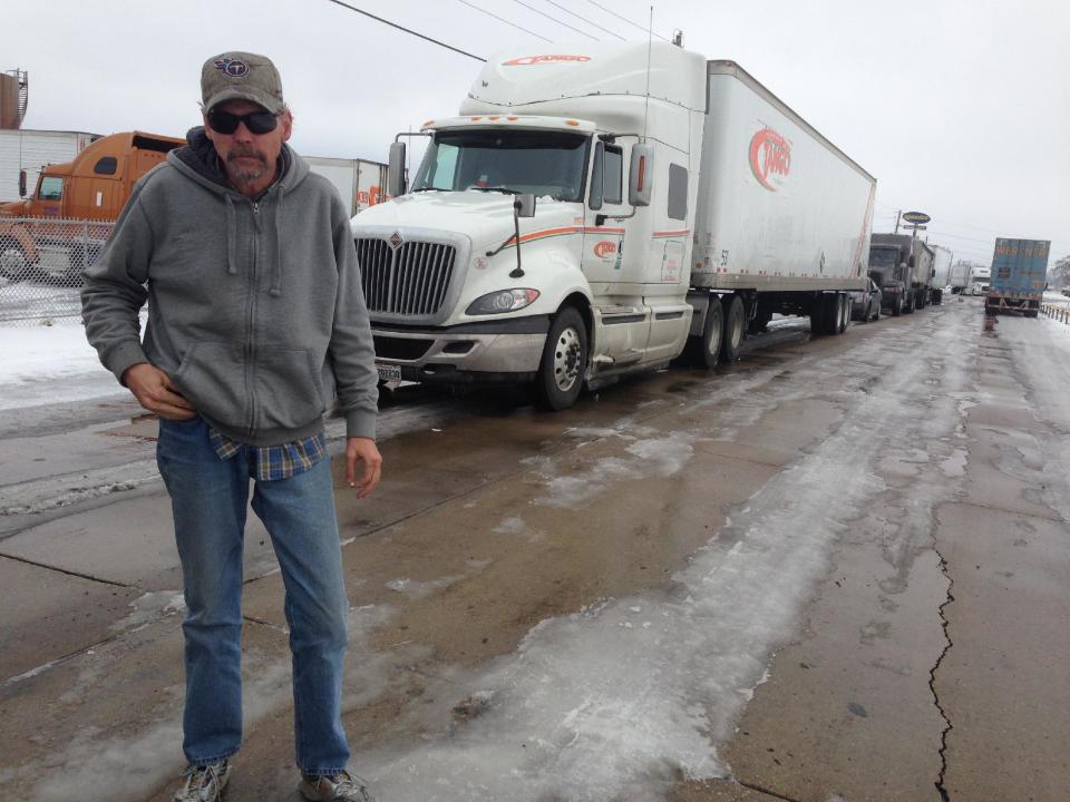 Truck driver Ted Simpson stands in front of his truck as he waits in line to get to a truck stop to pump fuel on Tuesday, March 4, 2014 in West Memphis, Ark. Simpson got off an icy interstate as he was passing through West Memphis hauling cardboard boxes from Murfreesboro, Tenn. to Russellville, Ark. (AP Photo/Adrian Sainz)