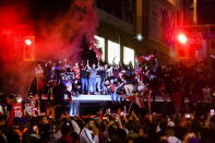 Fans stand on a transit vehicle as fellow supporters celebrate in the streets of Toronto after the Toronto Raptors defeated the Golden State Warriors 114-110 during Game 6 of basketball's NBA Finals in Oakland, Calif., to win the league title, early Friday, June 14, 2019. (Nathan Denette/The Canadian Press via AP)