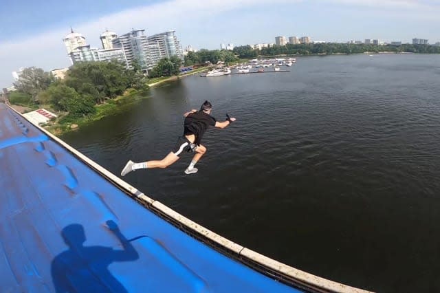 This heart-stopping footage shows a daredevil jumping from a speeding train into a river below