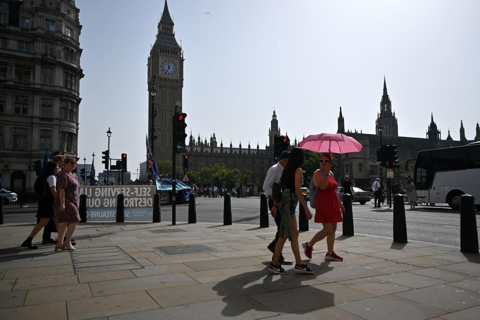 TOPSHOT - Pedestrians walk in the midday sun past the Palace of Westminster in central London on September 6, 2023 as the late summer heatwave continues. (Photo by JUSTIN TALLIS / AFP) (Photo by JUSTIN TALLIS/AFP via Getty Images)