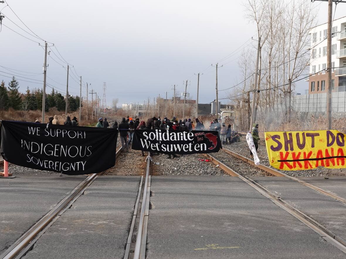 A group of protestors set up a rail blockade in Saint-Lambert on Saturday, causing the cancellation and delay of trains between Montreal and Quebec City. The group said they were acting in solidarity with the Gidimt'en clan of the Wet'suwet'en nation in B.C. that's been opposing a natural gas pipeline on its territory. (Mathieu Wagner/Radio-Canada - image credit)