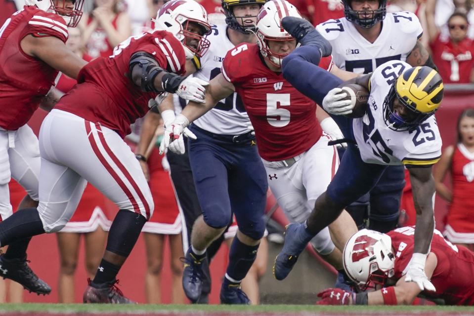 Michigan's Hassan Haskins is tripped up during the second half of an NCAA college football game Saturday, Oct. 2, 2021, in Madison, Wis. (AP Photo/Morry Gash)