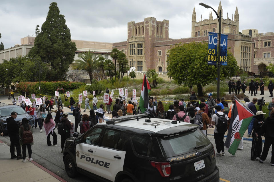 Pro-Palestinian protesters carry signs and march along the campus of UCLA on Thursday, May 23, 2024, in Los Angeles. (AP Photo/Damian Dovarganes)