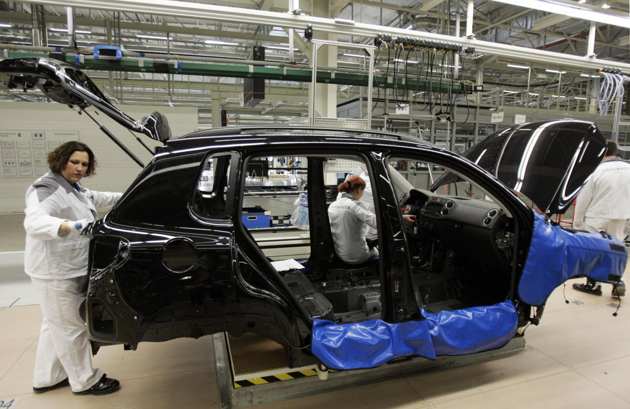 Employees at a Volkswagen factory work on an assembly line in the city of Kaluga, 188 km (117 miles) southwest of Moscow, October 20, 2009. Volkswagen's subsidiary in Russia is launching full-cycle production of cars in the city of Kaluga, RIA Novosti news agency reported. REUTERS/Alexander Natruskin  (RUSSIA BUSINESS TRANSPORT)