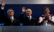 FILE PHOTO: International Olympic Committee (IOC) President Thomas Bach of Germany and Russian President Vladimir Putin wave as gold medallist bobsleigh athlete Russia's Alexander Zubkov applauds (L-R) during the closing ceremony for the 2014 Sochi Winter Olympics, February 23, 2014. REUTERS/Phil Noble/File Photo