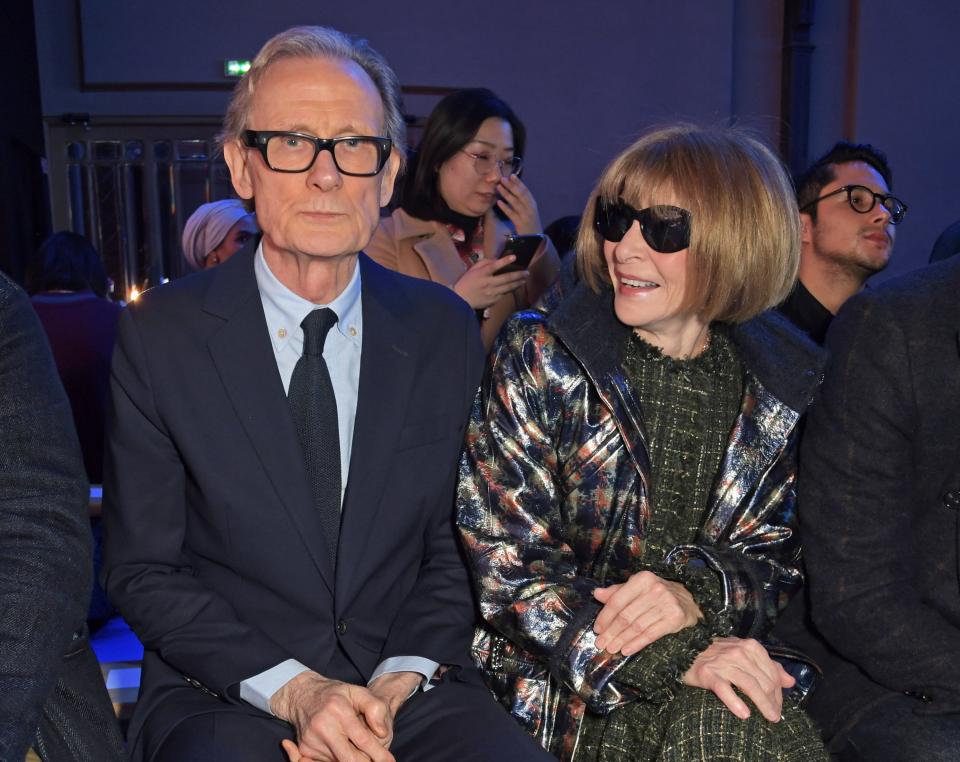 Anna and Bill sit side-by-side at a fashion show