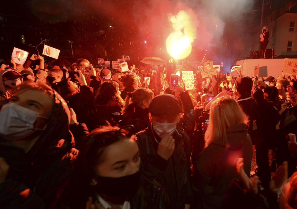 A crowd gathers outside the house of Poland's ruling conservative party leader Jaroslaw Kaczynski in Warsaw, Poland, Friday, Oct. 23, 2020. Protesters vented anger for a second day across Poland over a court ruling that declared abortions of fetuses with congenital defects unconstitutional. The hundreds of protesters who gathered in many cities defied a COVID-19-related ban on gatherings that was imposed nationwide on Friday. (AP Photo/Czarek Sokolowski)