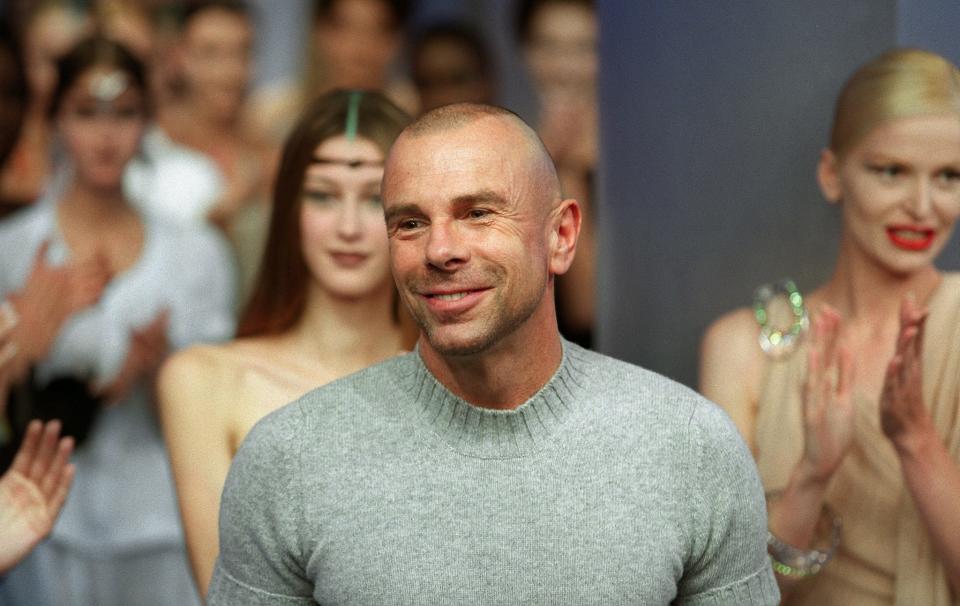 In this photo taken on October 3, 1999, French fashion designer Thierry Mugler is cheered by his models and the audience after the presentation of his Spring/Summer 2000 ready-to-wear collection in Paris. French designer Thierry Mugler, who reigned over fashion in the 1980s, died on January 23, 2022 at the age of 73.