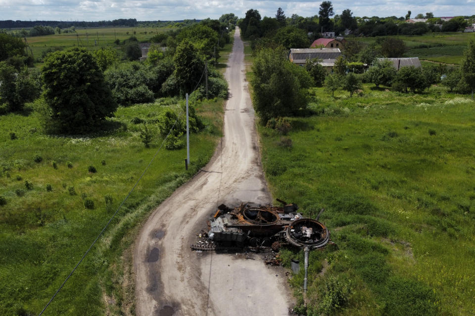 A ruined tank on a road in Lypivka, on the outskirts of Kyiv, Ukraine, Tuesday, June 14, 2022. Russia’s invasion of Ukraine is spreading a deadly litter of mines, bombs and other explosive devices that will endanger civilian lives and limbs long after the fighting stops. (AP Photo/Natacha Pisarenko)