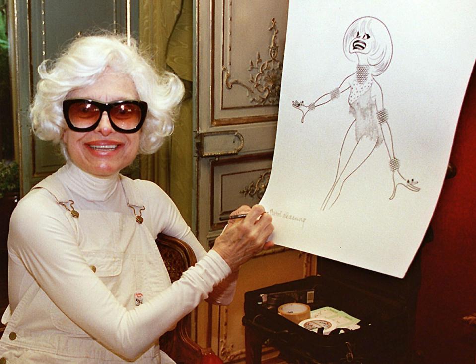 En esta foto del 1 de noviembre de 1997, la actriz Carol Channing firma una litografía de ella misma hecha por el caricaturista Al Hirschfeld en su casa en Beverly Hills, California. Channing, cuya carrera abarcó décadas en Broadway y la televisión, murió el martes 15 de enero del 2019. Tenía 97 años. (AP Foto/Damian Dovarganes, Archivo)