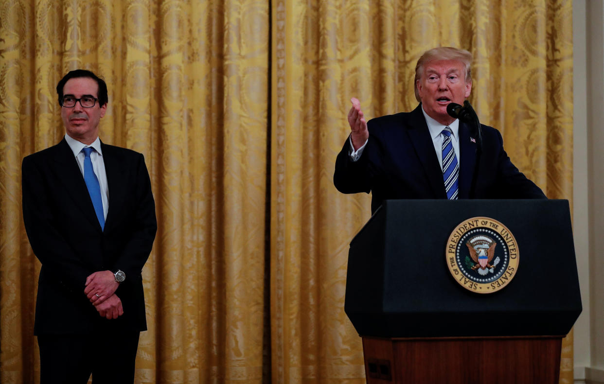 Treasury Secretary Steven Mnuchin (left) sought to keep the names of Paycheck Protection Program recipients secret for weeks. On April 28, he watched as President Donald Trump spoke about PPP loans in the White House East Room. (Photo: Carlos Barria/Reuters)