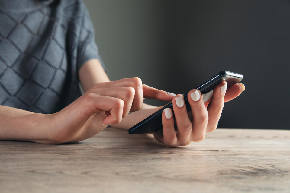 Close up hand of woman using smartphone