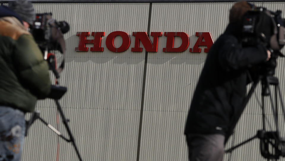 Journalists film outside the North Gate of the Honda car plant in Swindon, western England, Tuesday, Feb. 19, 2019. The Japanese carmaker Honda announced Tuesday that its Swindon car plant will close with the potential loss of some 3,500 jobs. (AP Photo/Frank Augstein)