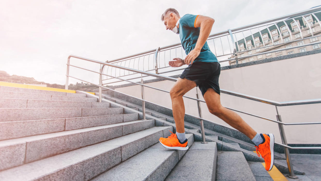 healthy lifestyle middle aged man runner running upstairs on cit.