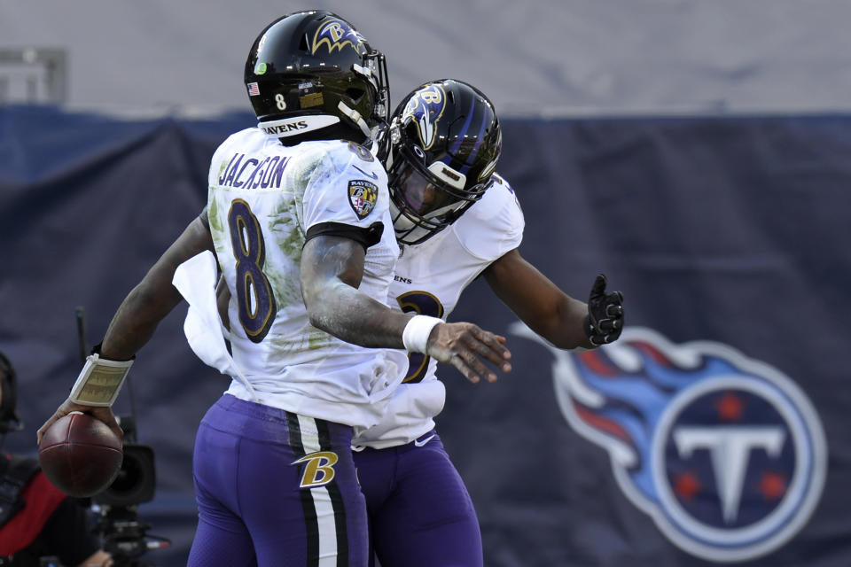 Baltimore Ravens quarterback Lamar Jackson (8) celebrates with running back Justice Hill after Jackson scored a touchdown on a 48-yard run against the Tennessee Titans in the first half of an NFL wild-card playoff football game Sunday, Jan. 10, 2021, in Nashville, Tenn. (AP Photo/Mark Zaleski)