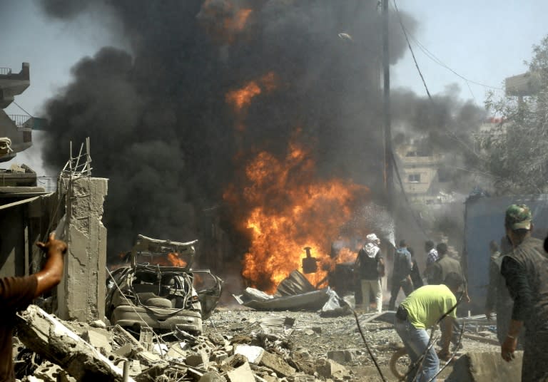 Residents gather at the site of a bomb attack in Syria's northeastern city of Qamishli on July 27, 2016