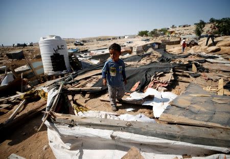 A Palestinian boy walks through the remains of a dwelling after it was demolished by Israeli forces in Abu Nuwar village in the occupied West Bank July 4, 2018. REUTERS/Mohamad Torokman