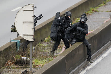 Members of the French police special force advance with their equipment on the Paris ring road near the scene of a hostage taking at a kosher supermarket in eastern Paris January 9, 2015. REUTERS/Youssef Boudlal