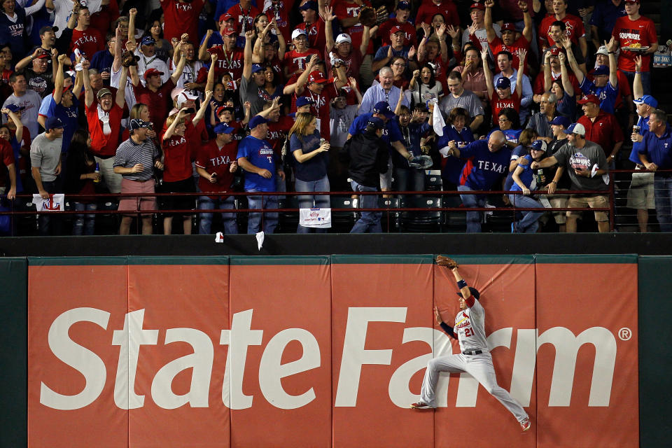 ARLINGTON, TX - OCTOBER 22: Allen Craig #21 of the St. Louis Cardinals leaps against the wall as Nelson Cruz #17 of the Texas Rangers hits a home run in the fourth inning during Game Three of the MLB World Series at Rangers Ballpark in Arlington on October 22, 2011 in Arlington, Texas. (Photo by Tom Pennington/Getty Images)