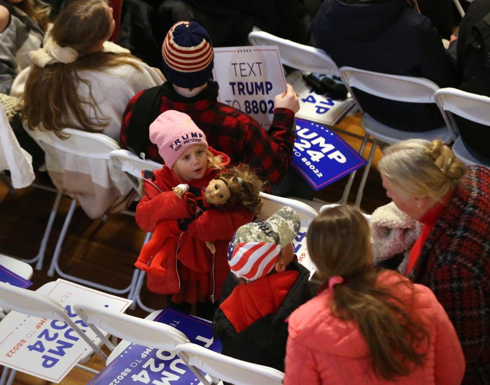 A young girl holds her doll wearing a hat supporting Donald Trump hours before he speaks at the Rochester (N.H.) Opera House Sunday, Jan. 21, 2024.