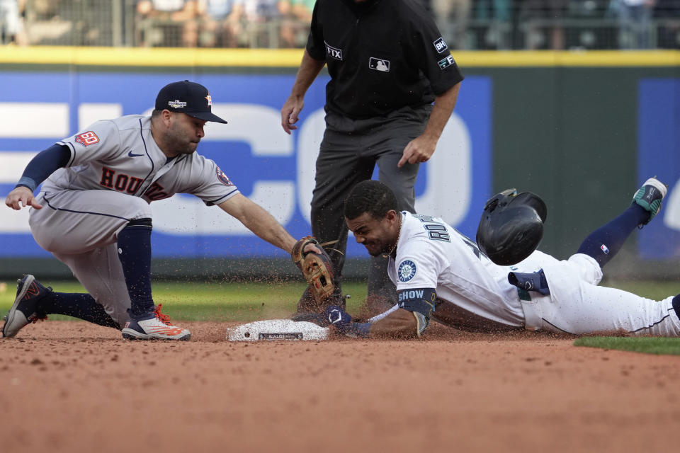 Seattle Mariners' Julio Rodriguez (44) slides safely into second base for a double under Houston Astros second baseman Jose Altuve during the eighth inning in Game 3 of an American League Division Series baseball game Saturday, Oct. 15, 2022, in Seattle. (AP Photo/Ted S. Warren)