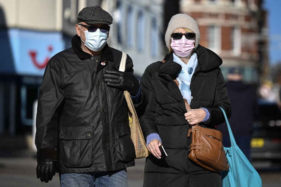 MERTHYR TYDFIL, WALES - NOVEMBER 06: A man and woman wearing face masks and sunglasses walk through the town centre on November 6, 2020 in Merthyr Tydfil, Wales. Merthyr Tydfil, with 741 cases per 100,000 people in the past week, has moved above Oldham and Blackburn in Lancashire as the worst-hit area in the UK. Wales is currently in a 'firebreak' lockdown which started on October 23 and will end on November 9. (Photo by Matthew Horwood/Getty Images)