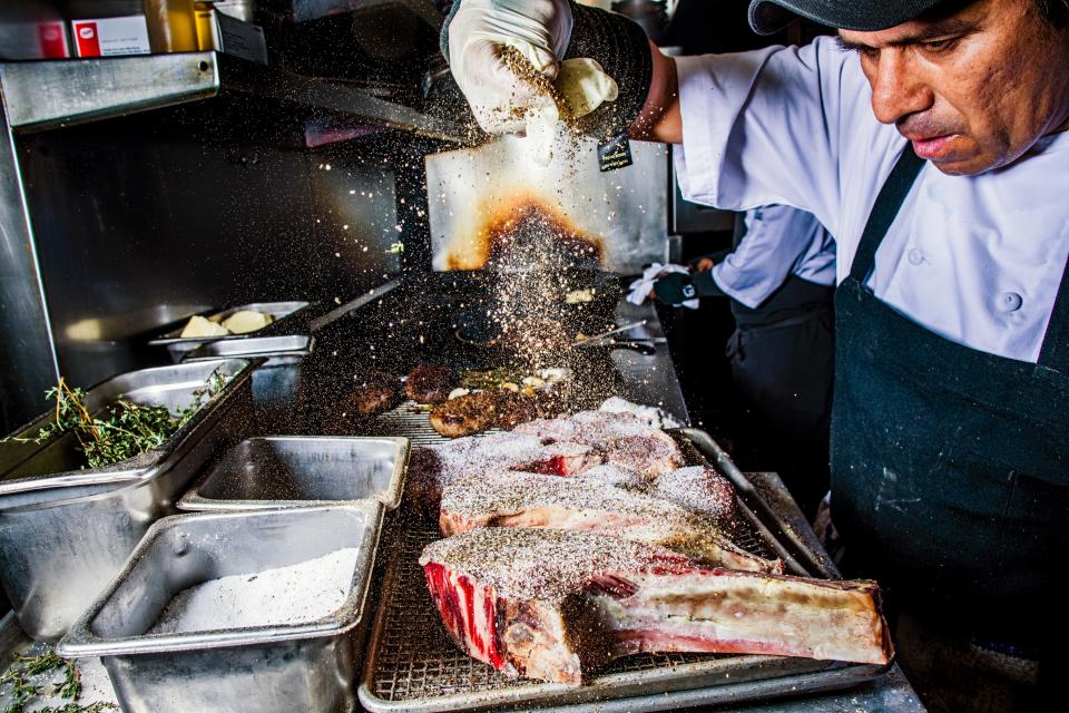 The serious preparation of steaks—and service (below)—at Georgia James in Houston.