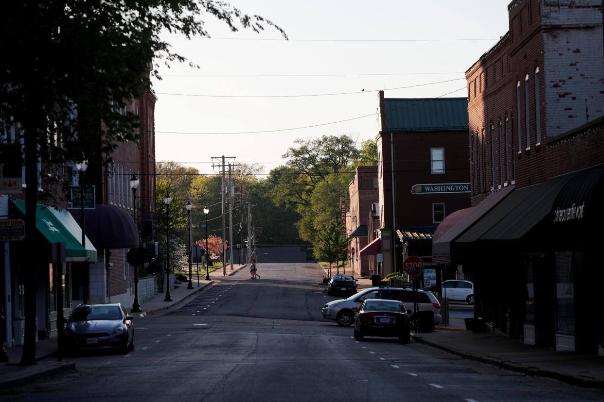 People walk across a street on Sunday, April 26, 2020, in Washington, Mo. The small town along the Missouri River was relatively quiet on Sunday even after some businesses such as movie theaters, fitness studios and tanning salons were told they could reopen as restrictions put in place to help slow the spread of the coronavirus are relaxed.