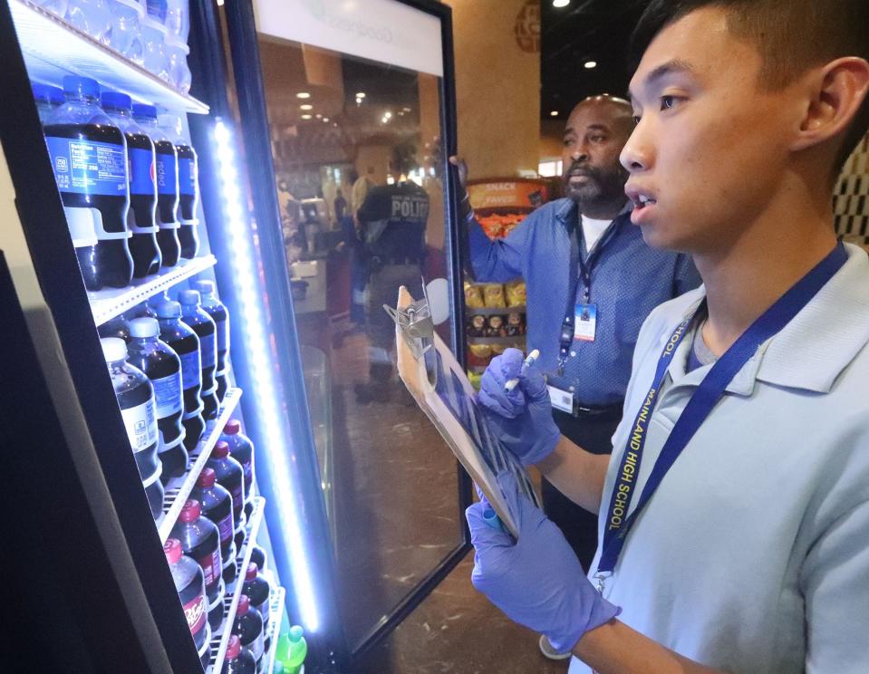 Project SEARCH student Aaron Huynh counts bottles to restock the drink cooler in the café, Thursday, Dec. 15, 2022, at Halifax Health Medical Center in Daytona Beach. Project SEARCH is a national program for students with disabilities who complete one-year internships to gain work experience and employability skills.