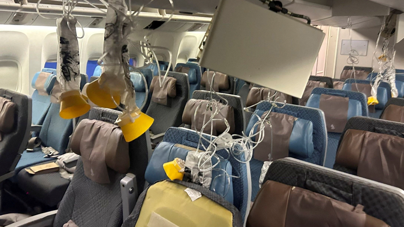 The interior of a plane with lots of oxygen masks hanging down