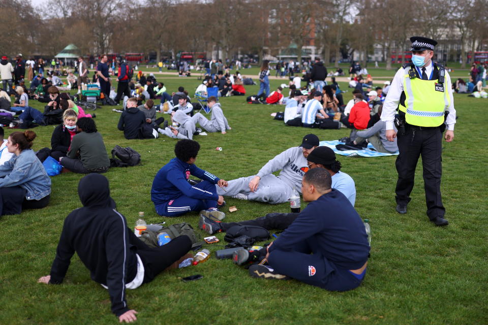 People sit and smoke during a demonstration to mark the informal cannabis holiday, 4/20, in Hyde Park, London, Britain, April 20, 2021. REUTERS/Tom Nicholson