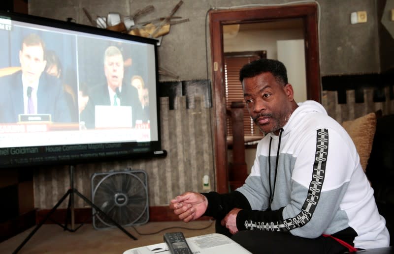 Voter Quincy Murphy watches the public hearing held by the House Permanent Select Committee on Intelligence as part of the impeachment inquiry into U.S. President Donald Trump, in his home in Flint