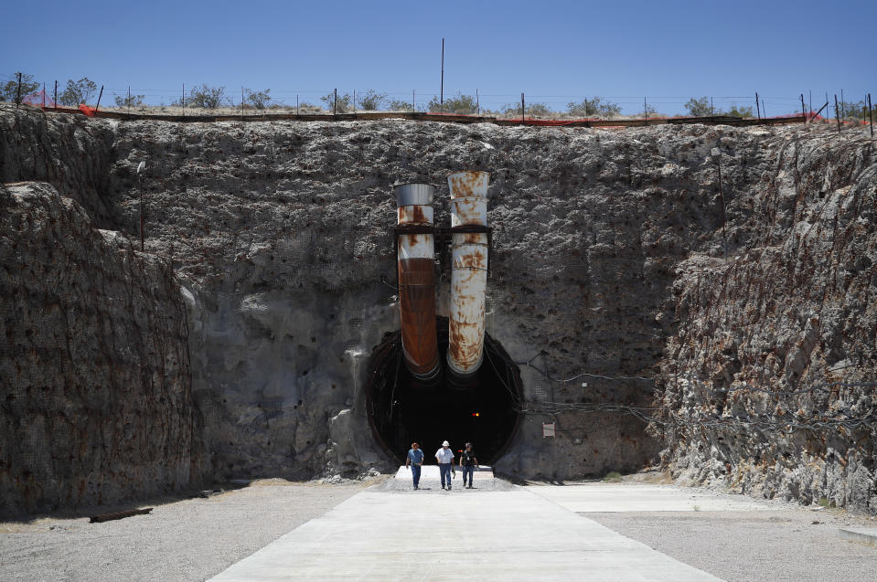 FILE - People leave the south portal of Yucca Mountain during a congressional tour on July 14, 2018, near Mercury, Nev. Nevada is asking the federal Nuclear Regulatory Commission to restart its look at licensing the mothballed Yucca Mountain national radioactive waste repository, with the expectation that will finally end four decades of debate and kill it. (AP Photo/John Locher, File)