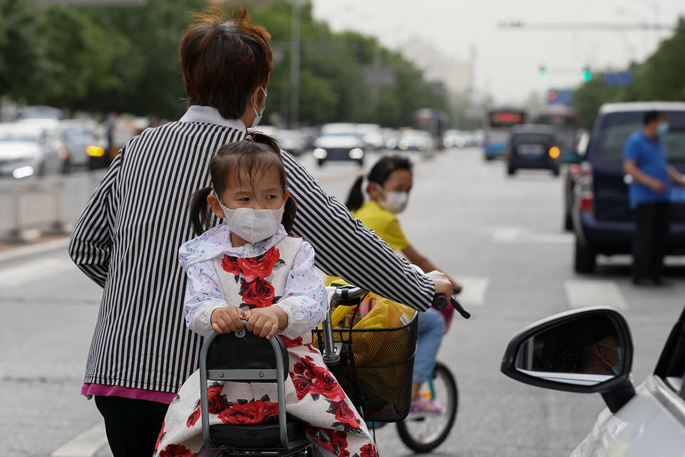 BEIJING, CHINA - MAY 11:  A young girl wearing face masks sitting on a bicycle on May 11, 2020 in Beijing, China. Life in Beijing is slowly returning to normal following a city-wide lockdown on January 25 to contain the coronavirus (COVID-19) outbreak.  (Photo by Lintao Zhang/Getty Images)