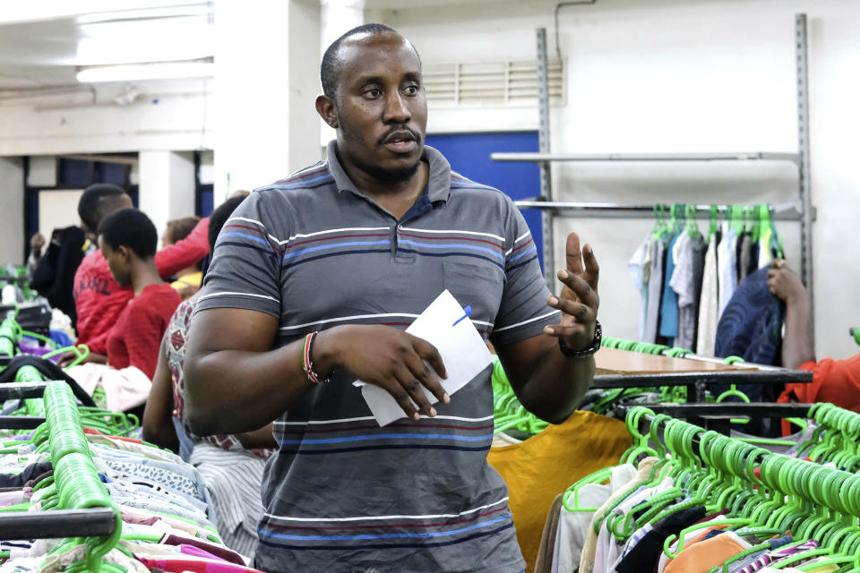 Retail manager Allan Zavuga speaks to the Associated Press at Green Shop, a chain specializing in used clothes, in Kampala, Uganda, Friday, Sept. 15, 2023. Downtown Kampala’s Owino Market has long been a go-to enclave for rich and poor people alike looking for affordable but quality-made used clothes, underscoring perceptions that Western fashion is superior to what is made at home. But, despite their popularity, secondhand clothes are facing increasing pushback. (AP Photo/Hajarah Nalwadda)