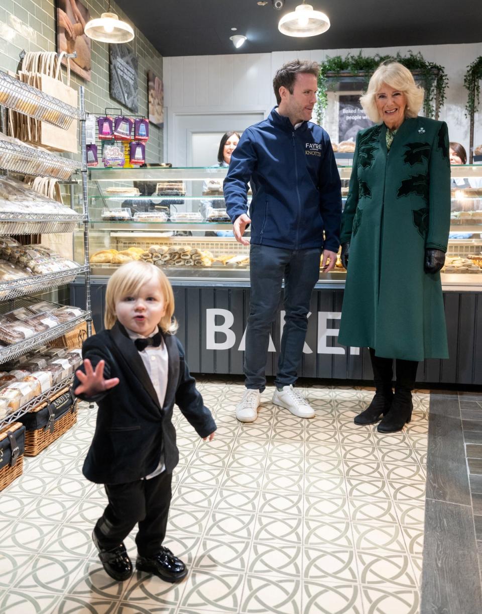 Queen Camilla looks on at Fitz William Salmon-Corrie in Knotts Bakery during her visit to Northern Ireland on Thursday (Reuters)