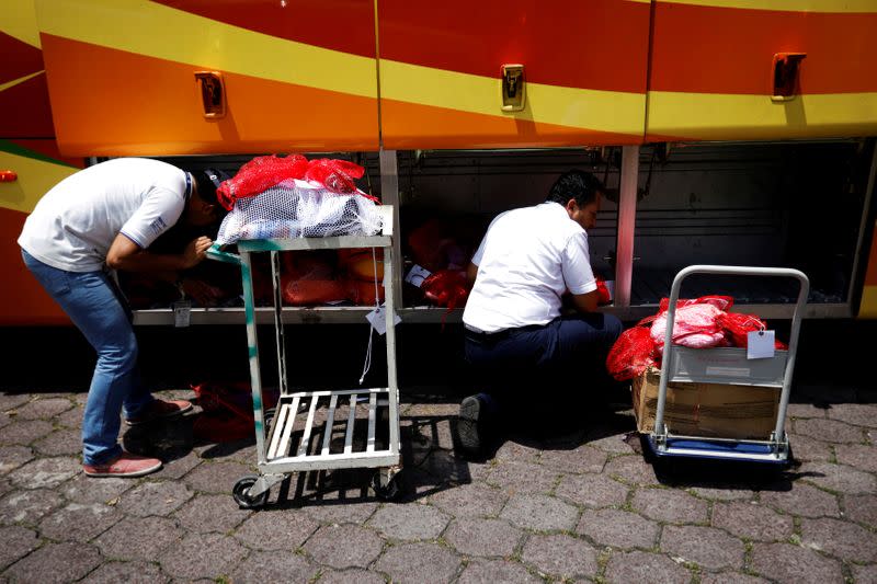 FILE PHOTO: Immigration workers process bags with belongings at an immigration facility after a flight carrying illegal immigrants from the U.S. arrived in San Salvador