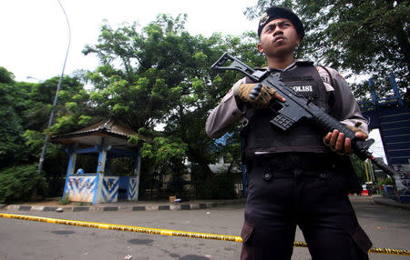 A policeman holds a rifle at location where a suspected supporter of Islamic State attacked policemen in Tangerang, Indonesia's Banten province, October 20, 2016, in this picture taken by Antara Foto. Antara Foto/Muhammad Iqbal/via REUTERS