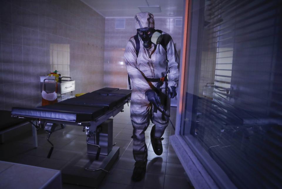 FILE In this file photo taken on Tuesday, May 5, 2020, a serviceman of Belarus Ministry of Defence wearing protective gear disinfects a local hospital in Minsk, Belarus. The 9.5-million Belarus has reported more than 68,500 infections, including 580 deaths, but critics have accused the authorities of manipulating statistics to hide the real number of deaths. (AP Photo/Sergei Grits)