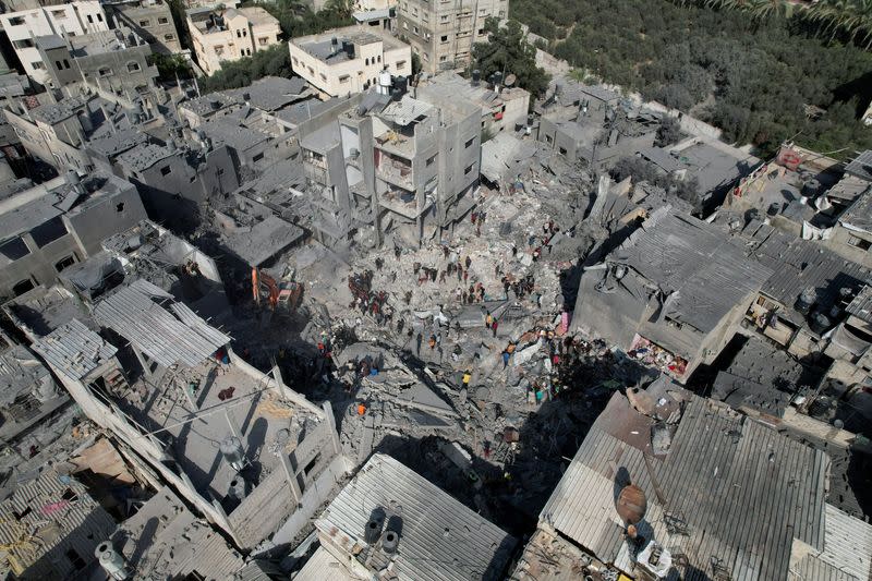 Palestinians search for casualties, at the site of Israeli strikes on houses, at the Magazi Refugee Camp