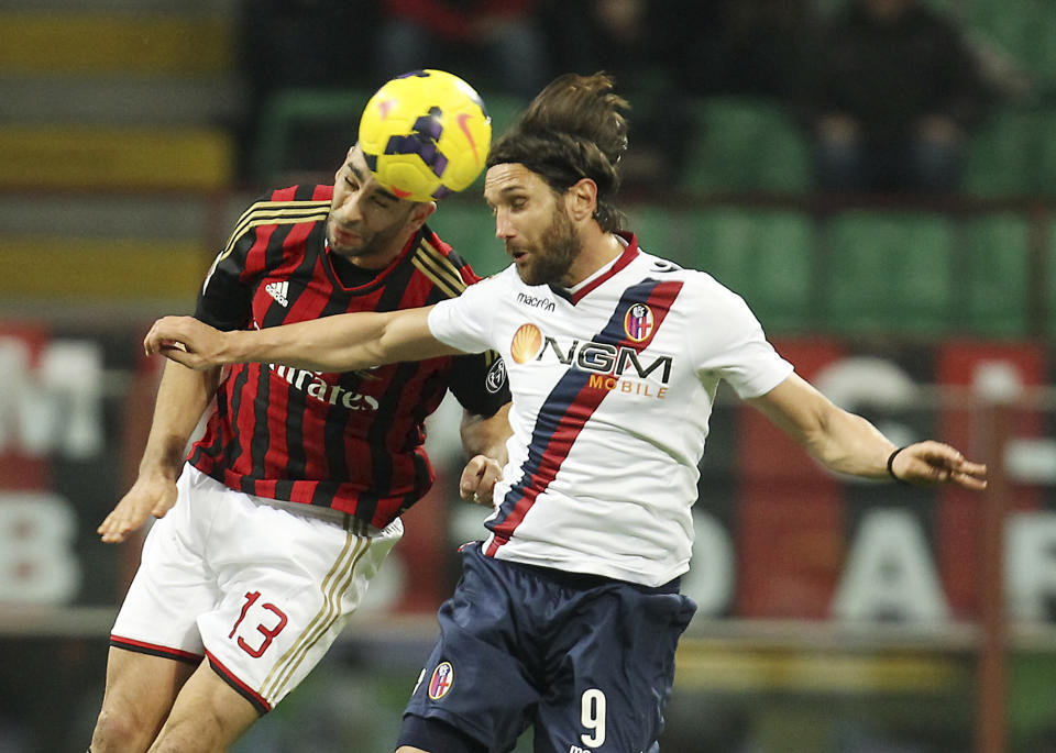 AC Milan defender Adil Rami, left, of France, jumps for the ball with Bologna forward Rolando Bianchi during the Serie A soccer match between AC Milan and Bologna at the San Siro stadium in Milan, Italy, Friday, Feb. 14, 2014. (AP Photo/Antonio Calanni)